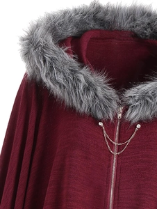 Detailed close-up of burgundy knit cape featuring faux fur collar and crystal metal chains