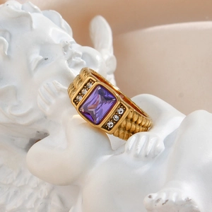 Detailed macro view of 18K gold plated ring with purple zircon on angel statue