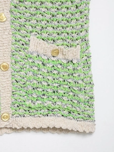 Detail of green wavy knit texture with cream ribbed trim and gold embossed buttons