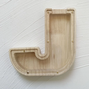 Close-up of J-shaped wooden piggy bank with transparent panel and visible wood grain texture