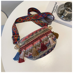 Detail of bohemian canvas crossbody bag with colorful tassels and jacquard weaving