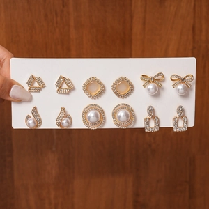 Detailed view of 12-piece gold stud earrings set with rhinestones and faux pearls