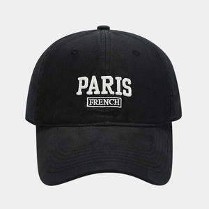 Close-up of white Paris French embroidery on a premium black cotton baseball cap