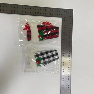 Detail view of plaid Christmas wine bottle covers with red berries and fur trim