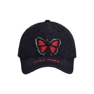 Close-up of butterfly embroidery and Free flight text on denim baseball cap