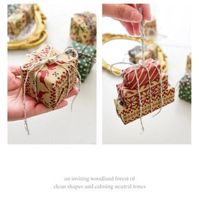 Close-up of mini Christmas gift boxes with reindeer and snowflake patterns for tree decor