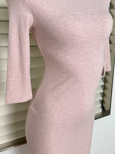Detailed view of light pink ribbed knit fabric and slim fit design of the midi dress