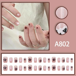 Short square press-on nails in nude pink with delicate black and pink star patterns