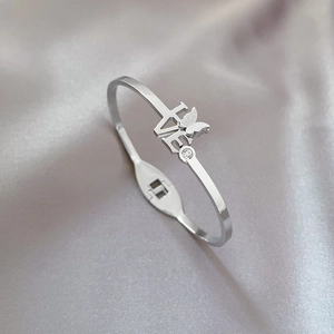 Titanium steel butterfly bangle with LOVE engraving and cubic zirconia on silk background