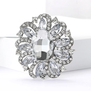 Close-up of a silver flower brooch with a large oval crystal and teardrop rhinestones