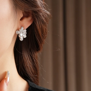 Dettaglio degli orecchini a fiore in argento e zircone indossati da una modella