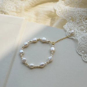 Irregular freshwater pearl bracelet with golden beads and an elegant extension chain