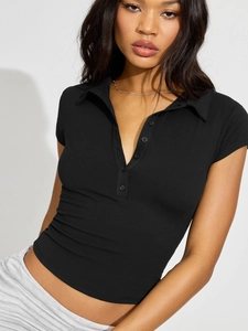 Close-up of black short-sleeved polo knit top with button placket and slim fit detail