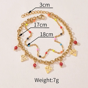Detail of gold double-layer bracelet featuring colorful beads and diamond pendants