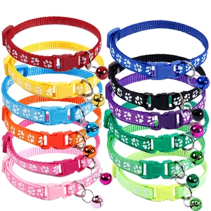 Vertical rows of colorful nylon pet collars with paw prints and metal bells on white back