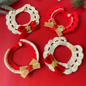 Detail of crochet Christmas pet collars with bows and stars on festive red background