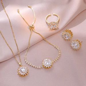 Golden sunflower jewelry set featuring zircon necklace, earrings, ring, and bracelet on silk