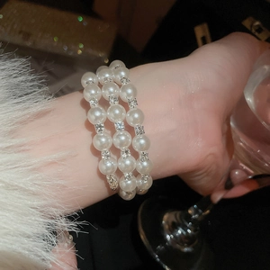 Detail of elegant double-layer pearl and diamond bracelet worn on a woman wrist