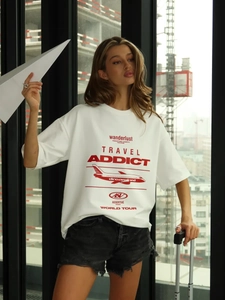 Dettaglio della maglietta bianca in cotone oversize con stampa rossa a tema viaggio