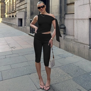 Detail von schwarzem One-Shoulder-Top mit Band und hoch taillierter Capri-Leggings