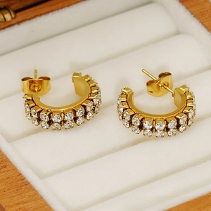 Macro detail of 18K gold-plated C-shaped earrings with double-row zircon pavé in a gift box