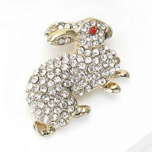 Close-up of golden rabbit brooch featuring full crystal rhinestones and a red stone eye
