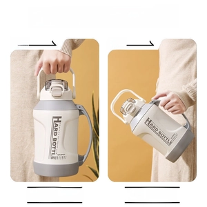 Close-up of insulated sports bottle showing dual carry handles and flip lid mechanism