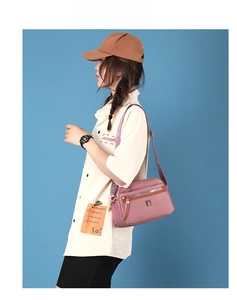 Detailed side view of purple nylon crossbody bag with multi-layer zippers and wide strap