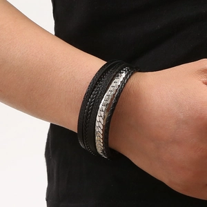 Close-up of a multi-layer black leather woven bracelet with silver magnetic metal clasp