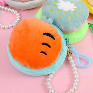 Close-up of plush fruit-shaped coin purses with pearl chains and secure zippers