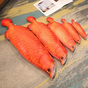 Detail showing five different sizes of realistic orange cartoon fish plush toys on a rug