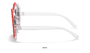 Detailed side view of red floral child sunglasses with transparent frames on white backdrop