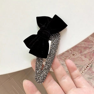 French style velvet bow hair clip with sparkling rhinestones in a handheld view