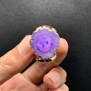 Detalle de anillo de racimo de cristal púrpura con piedra bruta y bordes bañados en oro 14K