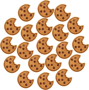 Macro detail of twenty chocolate chip cookie embroidered patches on white background
