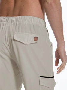 Close-up of beige cargo pants detailing elastic waist and functional back flap pocket
