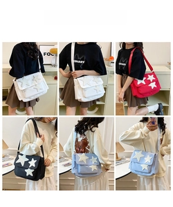 Detail view of the star-patterned canvas messenger bag in red, black, white, and blue colors