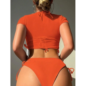Detail of orange high cut bikini set showing adjustable lace-up back and textured fabric