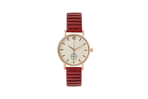 Détail macro d'une montre à quartz avec boîtier doré et bracelet rouge extensible