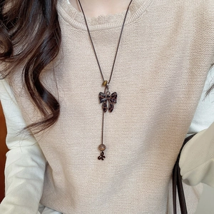 Gros plan d'un collier avec nœud léopard sur un pull en maille beige élégant