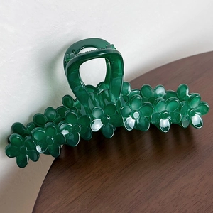 Detail shot of the dark green resin hair claw clip with multiple flower shapes