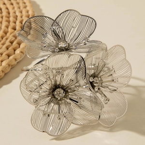 Detailed macro view of silver hollow floral bracelet with sparkling crystal centers