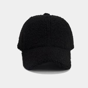 Close-up of black fuzzy faux shearling baseball cap showing warm textured material