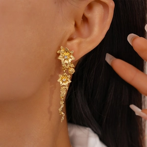 Gros plan d'une boucle d'oreille fleurie dorée avec strass sur l'oreille du mannequin