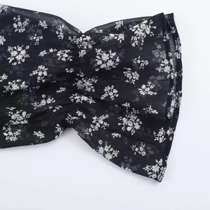 Detail of floral chiffon dress showing the ruffled cuffs and soft translucent texture