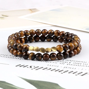 Detailed view of two tiger eye stone beaded bracelets with golden matte alloy charms