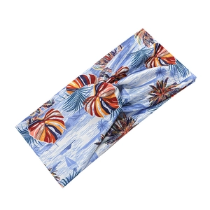 Detail view of a knotted sports headband featuring a tropical blue palm leaf and boat print