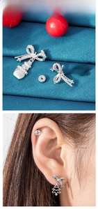 Detail of silver Christmas earrings featuring zircon snowman and Xmas tree designs
