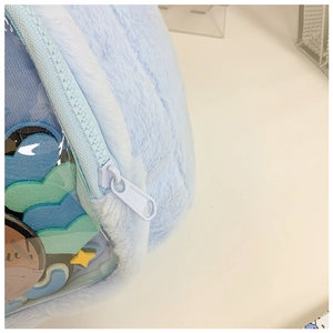 Detail of light blue plush bag featuring a transparent window with colorful heart shapes