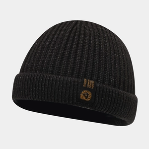 Détail d'un bonnet en maille noire avec écusson brodé jaune et design à bord replié